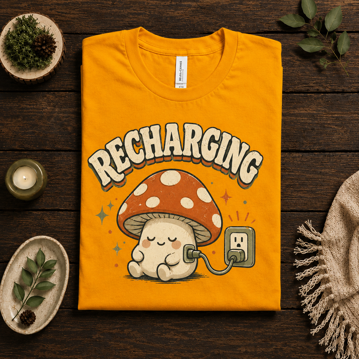 A folded mockup of Recharging Mushroom cute cottagecore graphic t-shirt in gold.