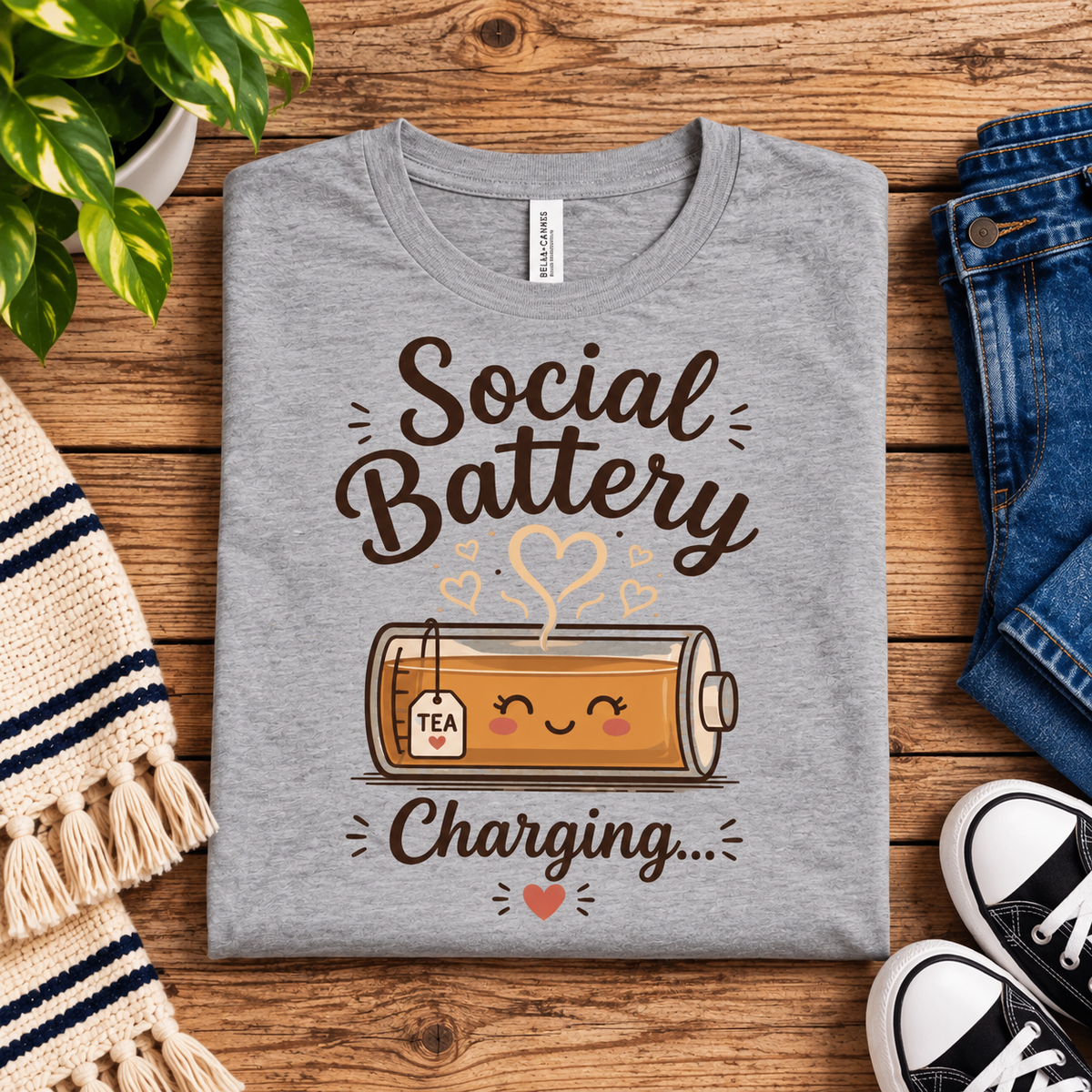 A folded mockup of Social Battery Tea cute tea graphic t-shirt in athletic heather.