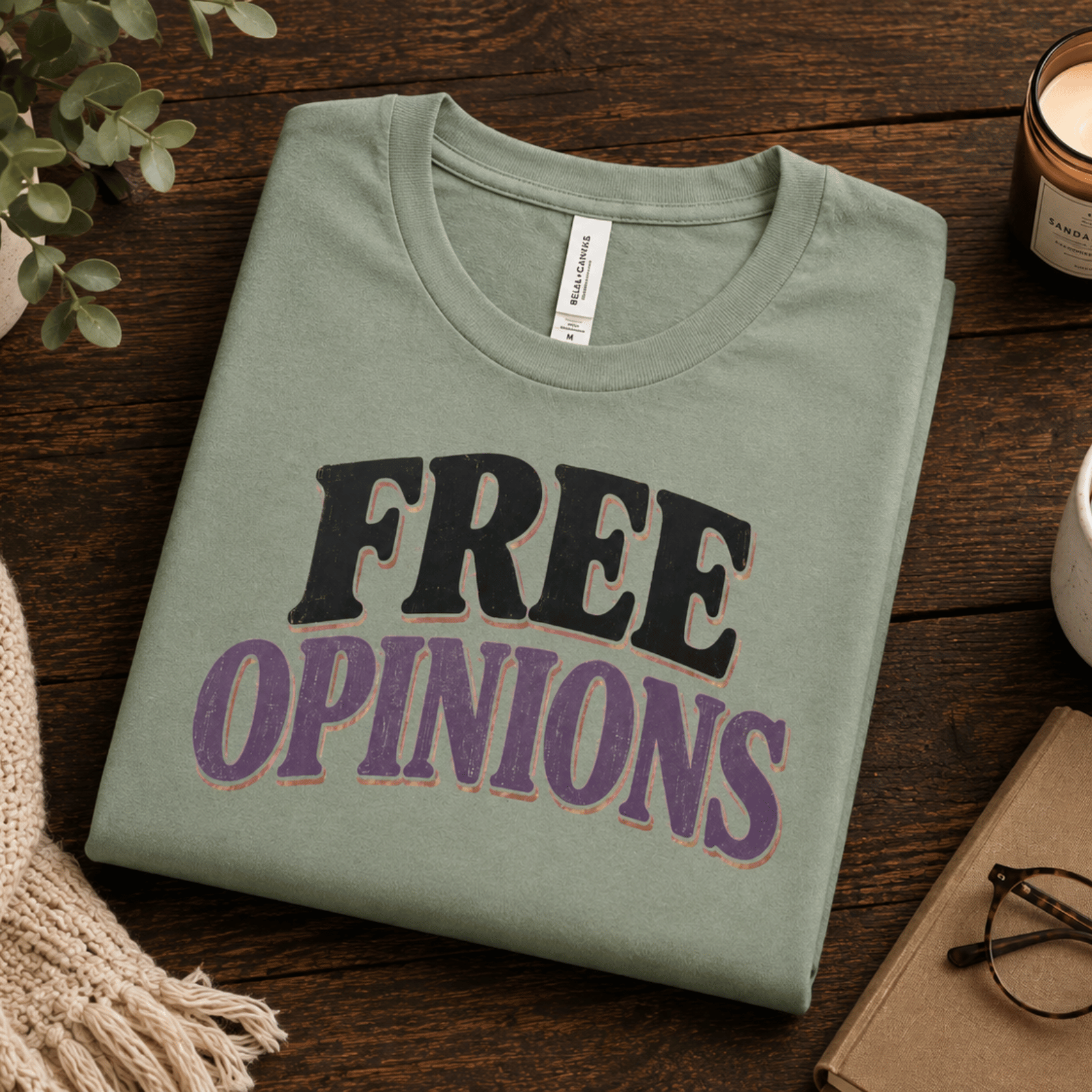 A folded mockup of Free opinions funny introvert graphic t-shirt in sage.