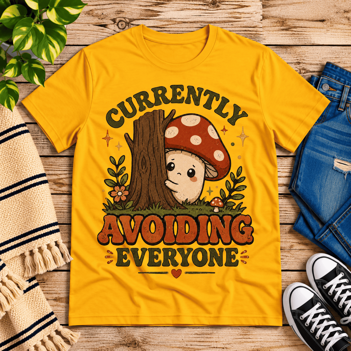 Currently Avoiding funny cottagecore graphic t-shirt cozy flat lay in gold.