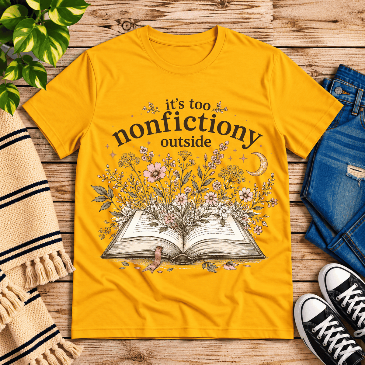 Nonfictiony whimsical book graphic t-shirt cozy flat lay in gold.