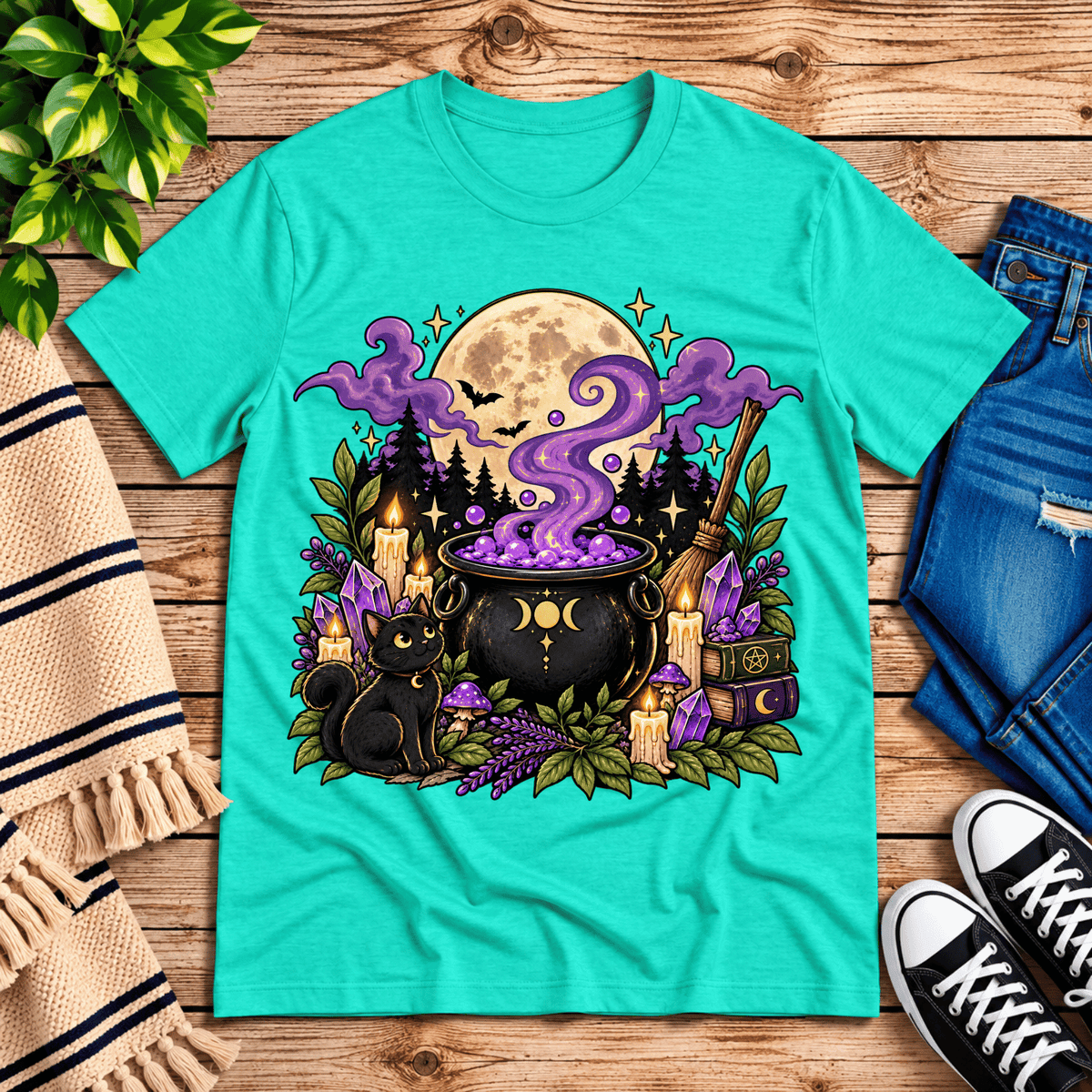 The cauldron cute celestial graphic t-shirt cozy flat lay in heather sea green.
