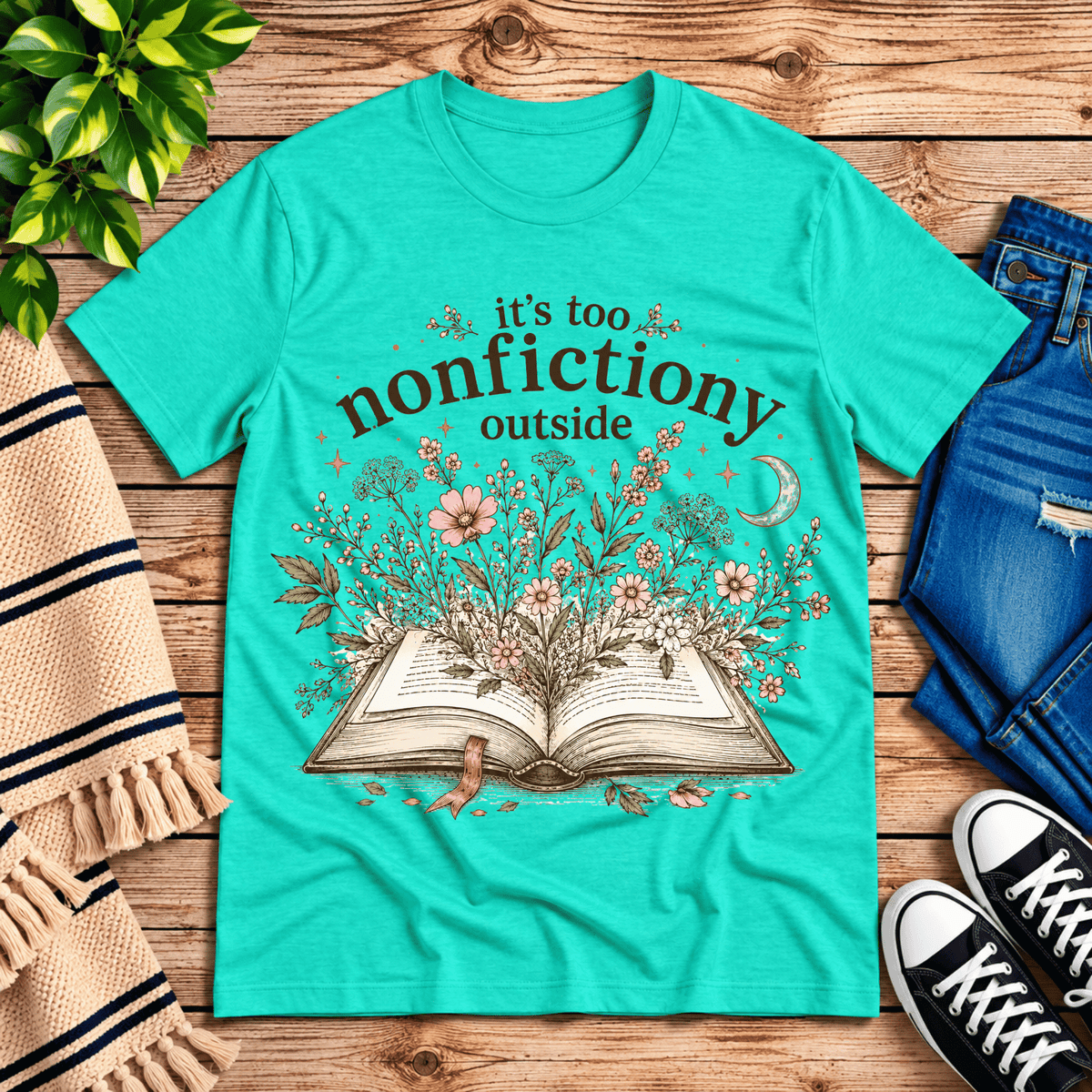 Nonfictiony whimsical book graphic t-shirt cozy flat lay in heather sea green.