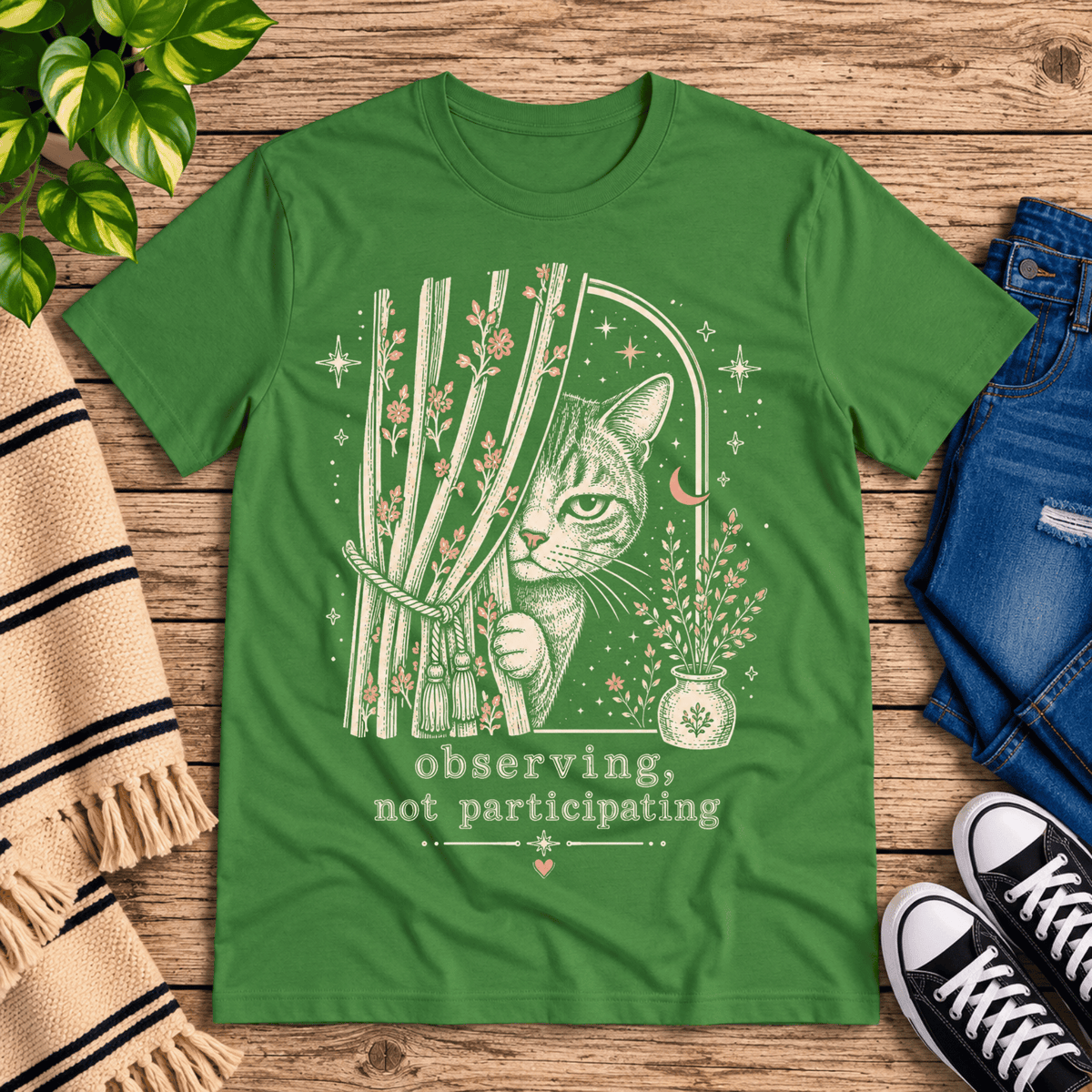 Cat Observing cute animal graphic t-shirt cozy flat lay in leaf.