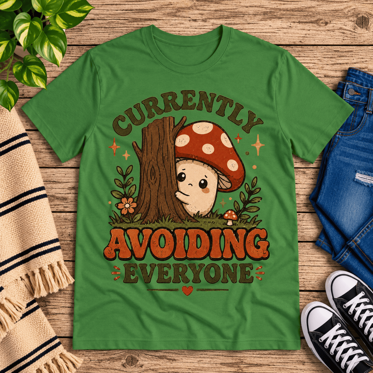 Currently Avoiding funny cottagecore graphic t-shirt cozy flat lay in leaf.