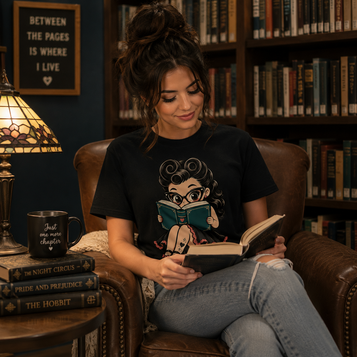 Woman in library wearing Bookworm Betty graphic t-shirt and reading a book.