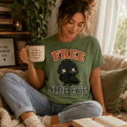 A woman wearing a leaf Free Side Eye graphic t-shirt drinking coffee.