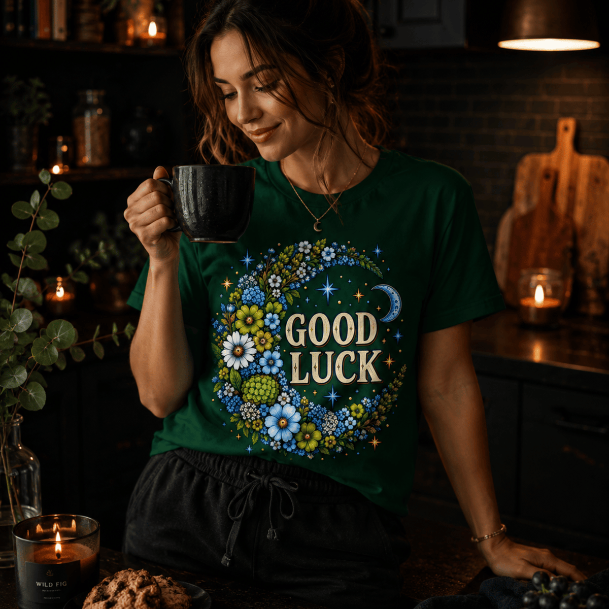 A woman wearing an evergreen Good Luck In Blue cute celestial graphic t-shirt drinking coffee.