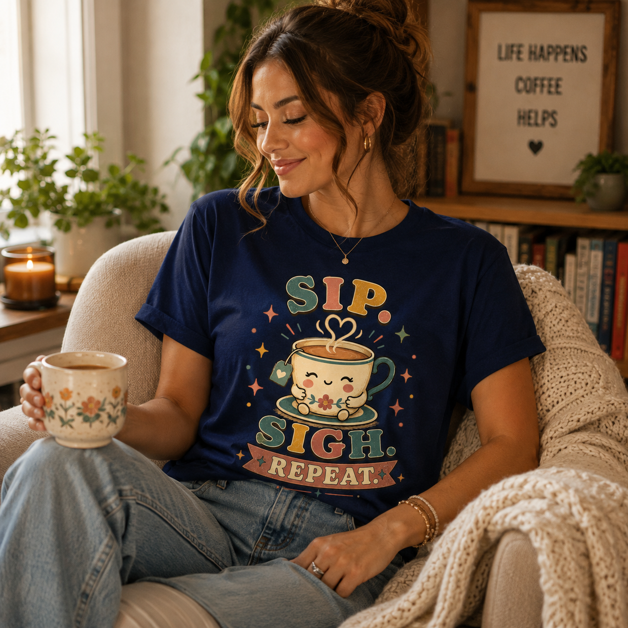A woman wearing Sip. Sigh. Repeat. in a navy graphic t-shirt in a living room.