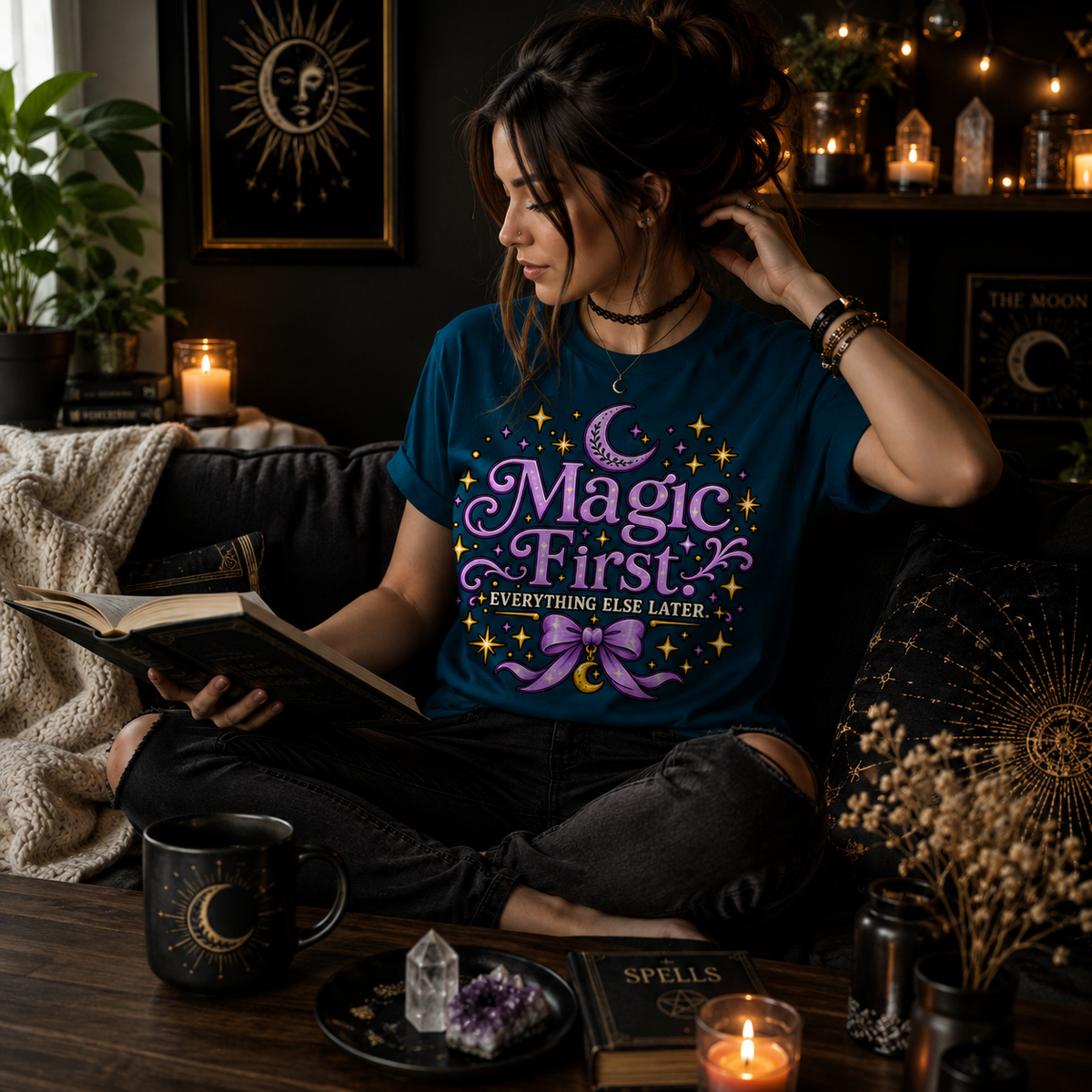 A woman wearing a deep teal Magic First cute celestial graphic t-shirt reading a book.