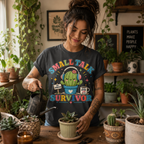 A woman wearing a asphalt Small Talk Survivor cute cactus graphic t-shirt watering cactus.