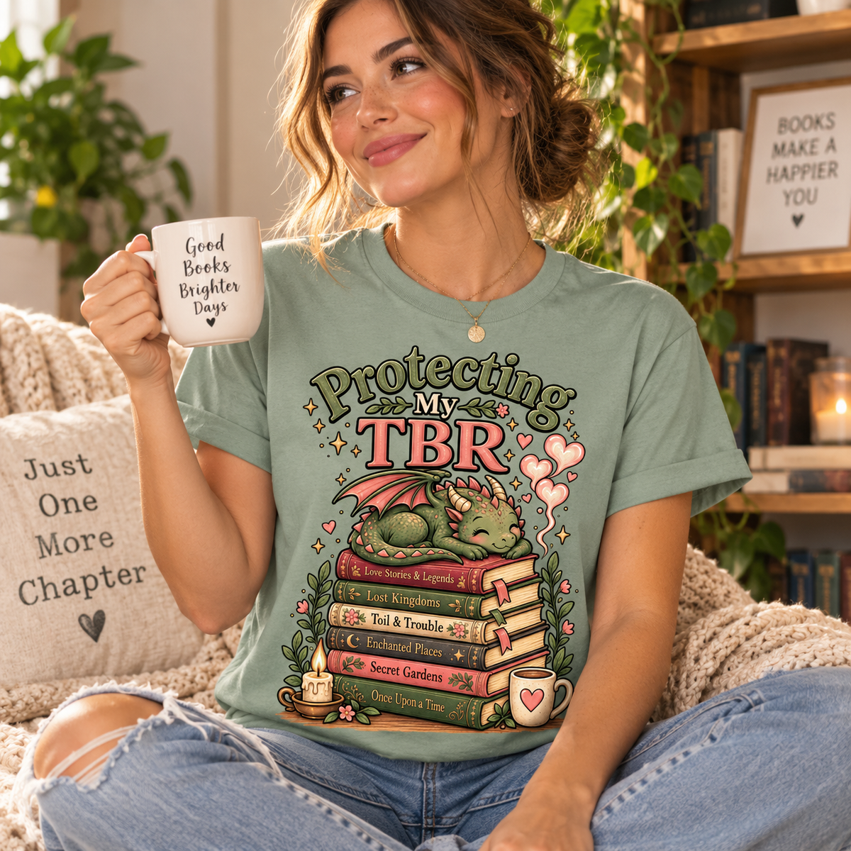 A woman wearing a Protecting My TBR cute book graphic t-shirt in sage.