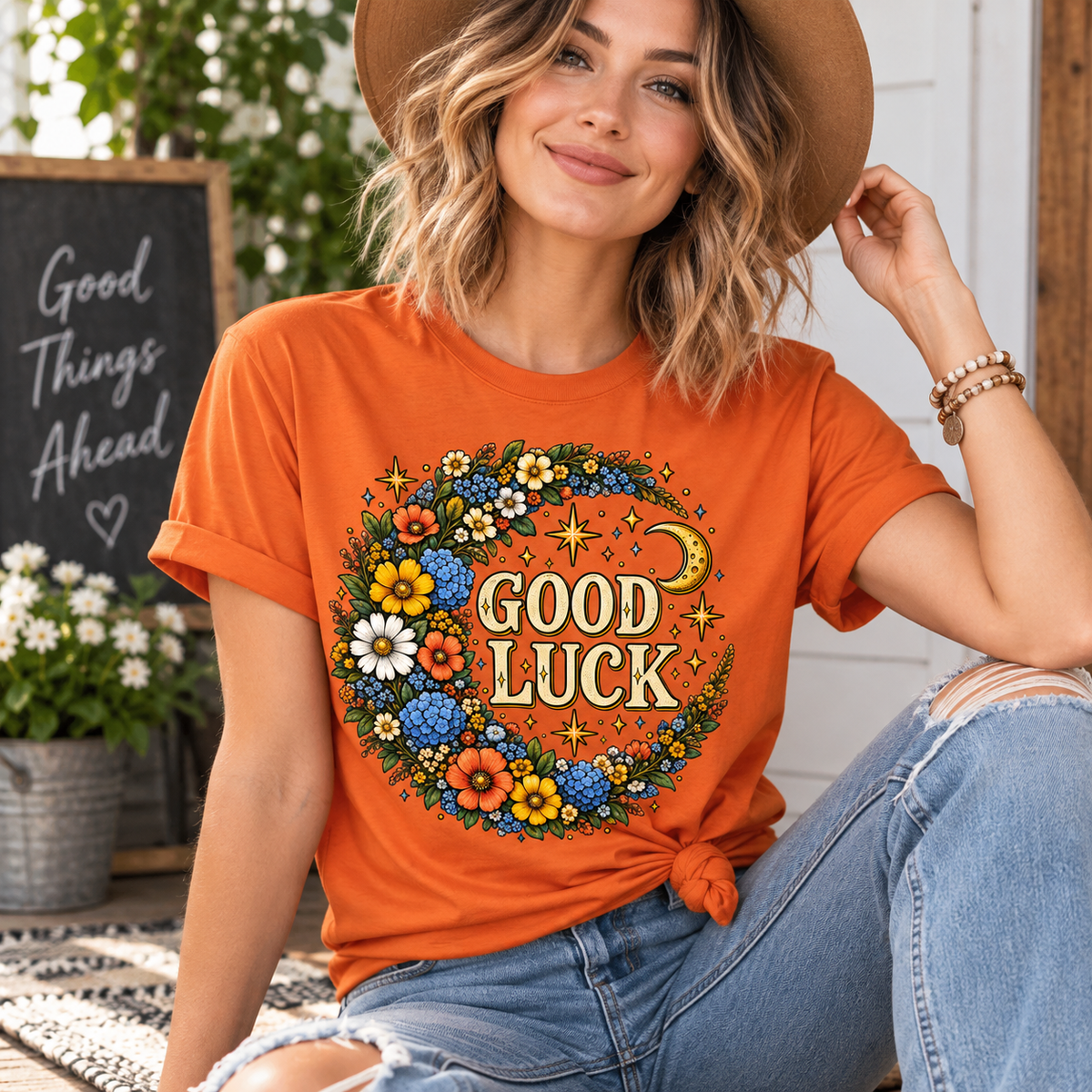 A woman wearing a burnt orange Good Luck Gold cute celestial graphic t-shirt.