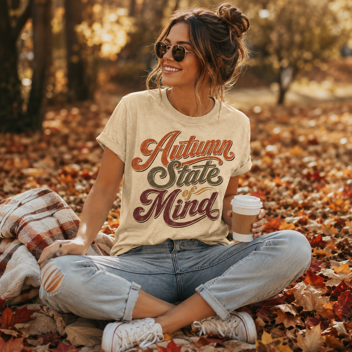 A woman wearing a natural Autumn State of Mind cute fall graphic t-shirt in an outdoor fall setting.