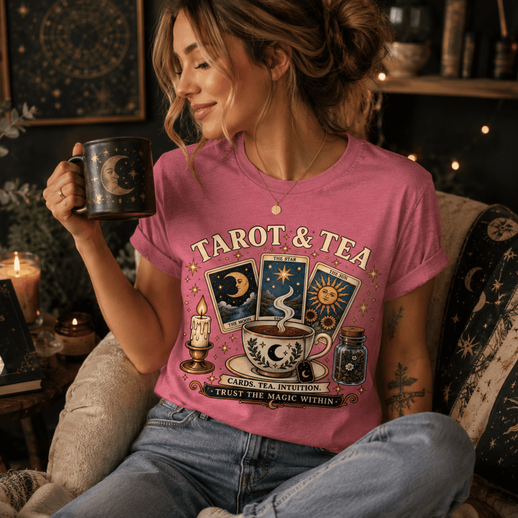 A woman wearing a charity pink Tarot & Tea charity pink graphic t-shirt drinking coffee.