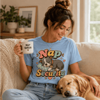 A woman wearing a baby blue Nap Security cute animal graphic t-shirt drinking coffee and petting her dog.