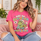 A woman wearing a charity pink Overthink Frog cute animal graphic t-shirt.