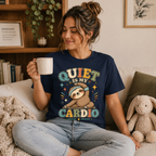 A woman wearing a navy Quiet Is My Cardio cute animal graphic t-shirt drinking coffee.