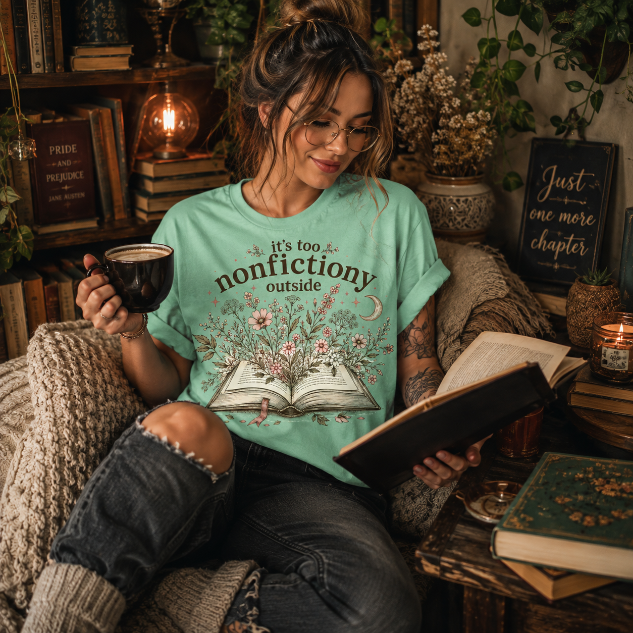 A woman wearing a mint Nonfictiony whimsical book graphic t-shirt reading a book.