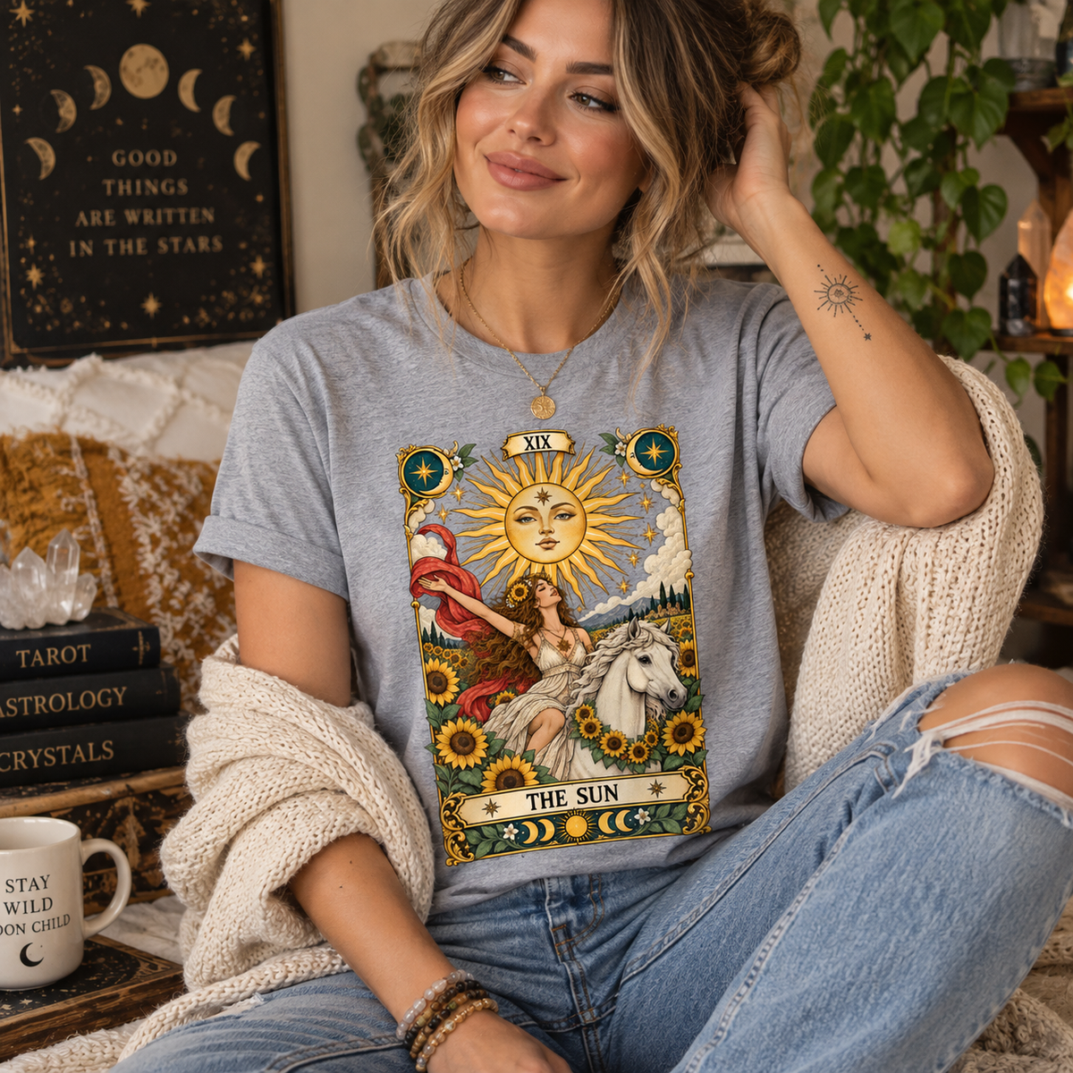 A woman wearing an athletic heather The Sun tarot card graphic t-shirt.