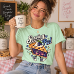 A woman wearing a mint Serving Pie retro food graphic t-shirt.
