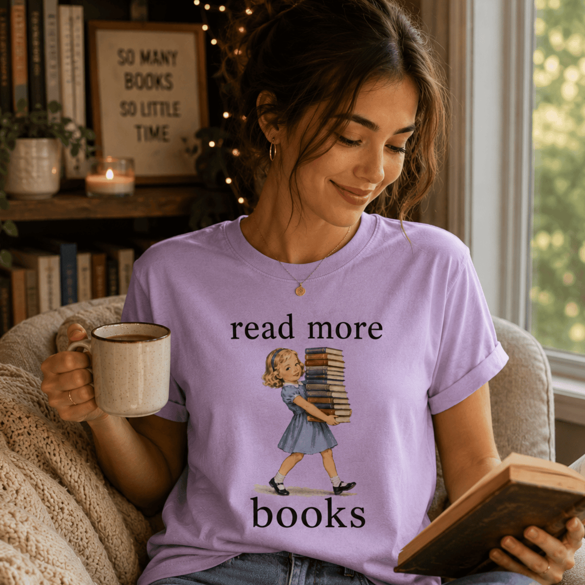 A woman wearing a lilac Read More vintage book graphic t-shirt reading a book.