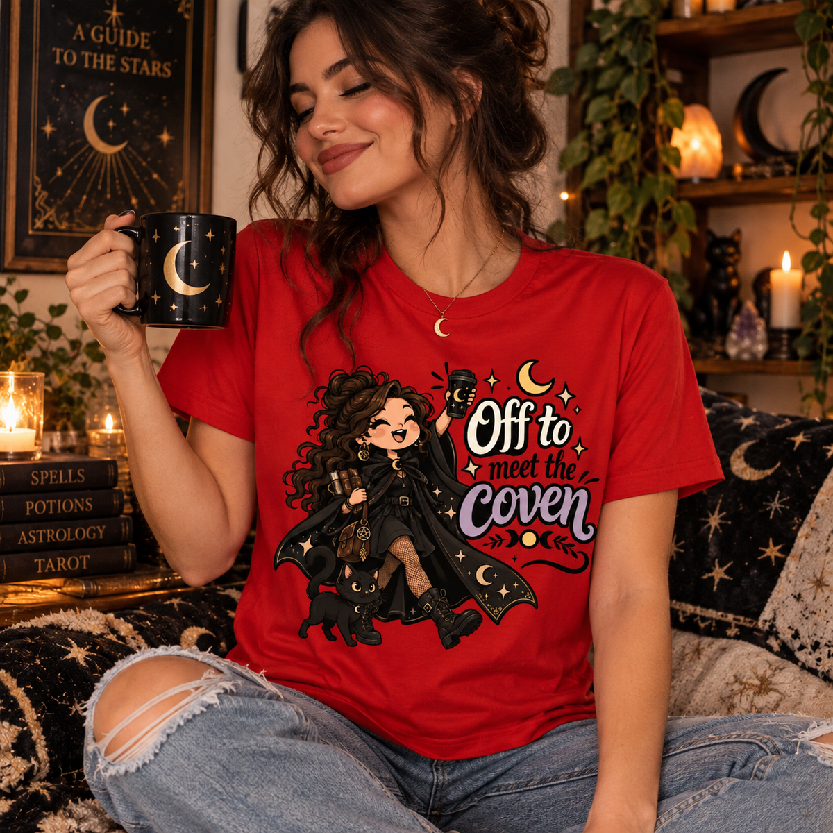 A woman wearing a red Off to Meet the Coven witchy celestial graphic t-shirt.