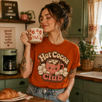 A woman wearing Hot Cocoa Club graphic Hot Cocoa Club t-shirt in a retro sage kitchen.