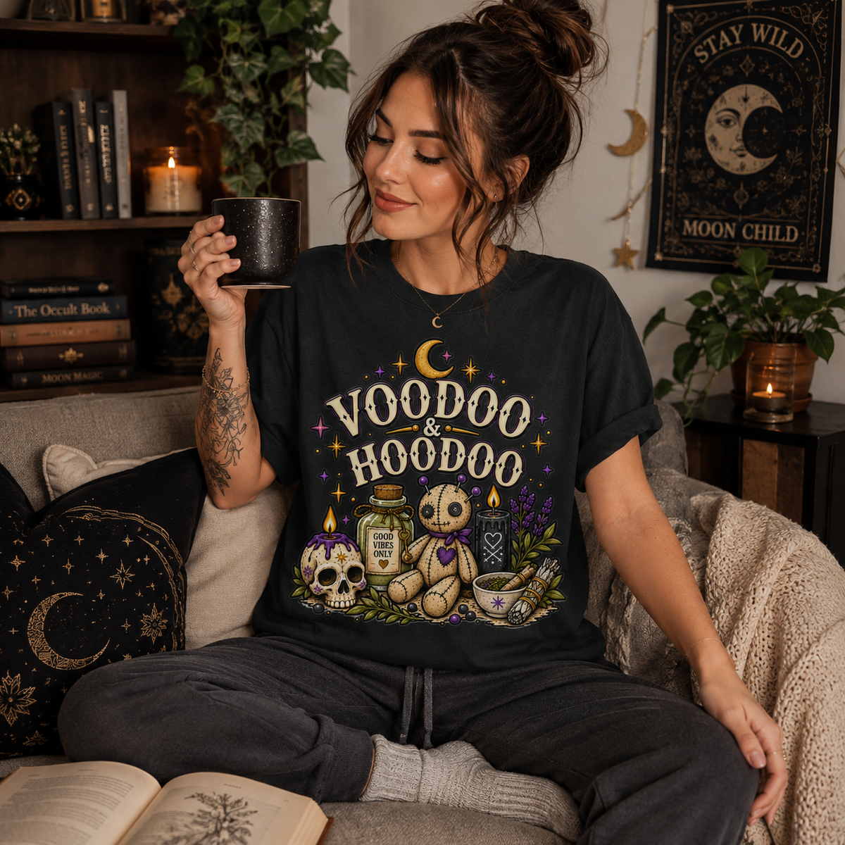 A woman wearing a vintage black Voodoo & Hoodoo celestial witchy graphic t-shirt drinking coffee.