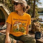 A woman wearing a gold Quiet Company nature lovers graphic t-shirt camping.