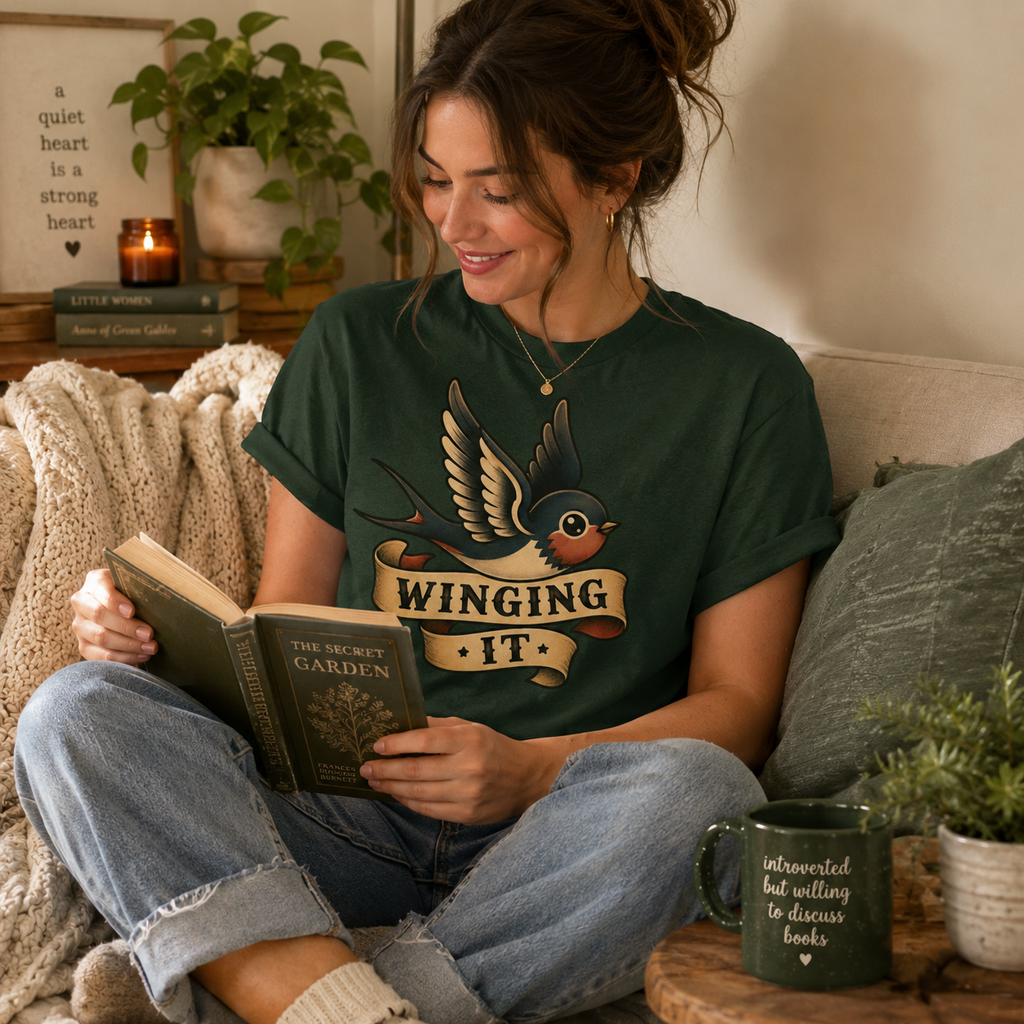 A woman wearing an evergreen Winging It cute animal graphic t-shirt drinking coffee.