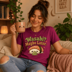 Woman wearing Wasabi graphic t-shirt in berry sitting on couch drinking coffee.