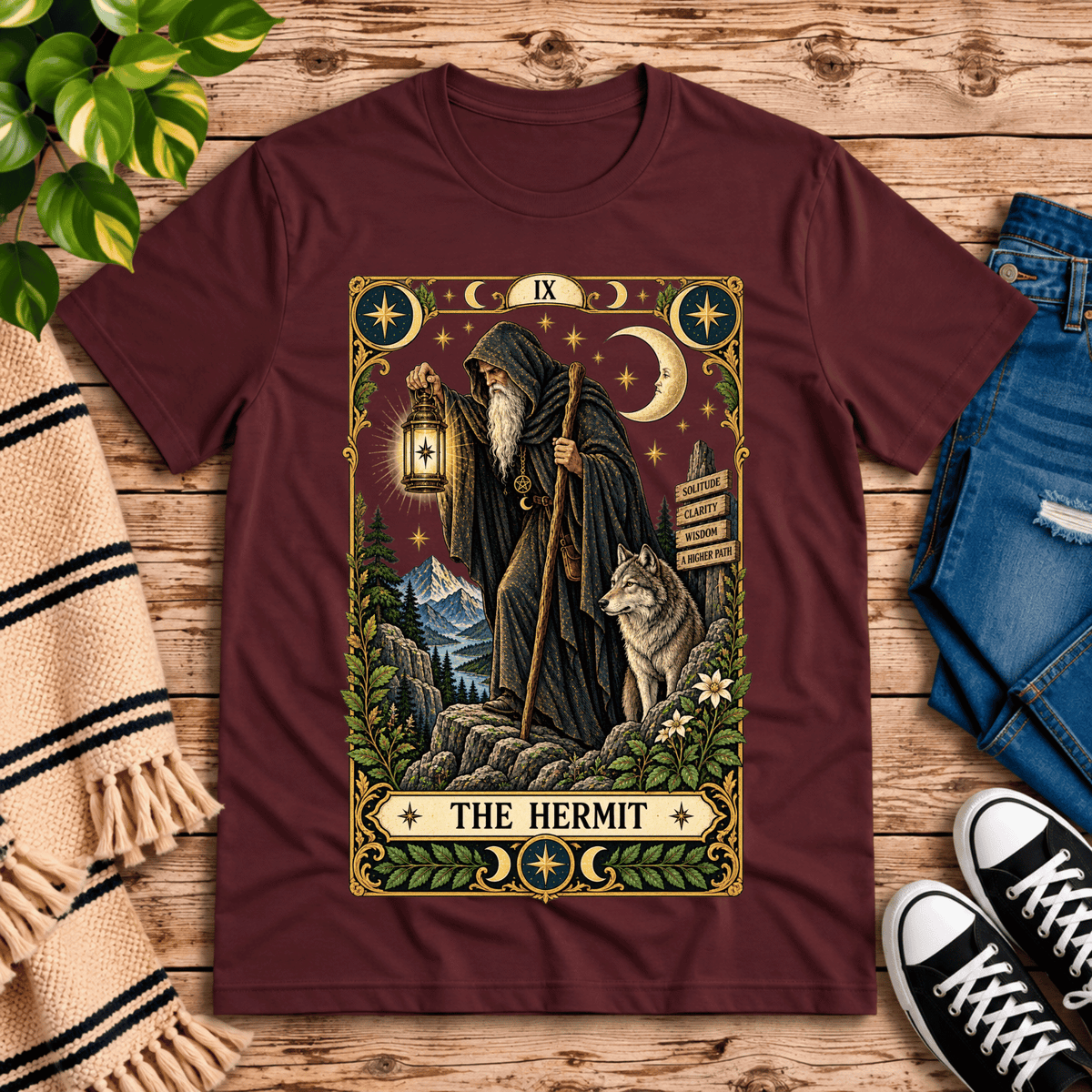 The Hermit tarot card graphic t-shirt cozy flat lay in maroon.