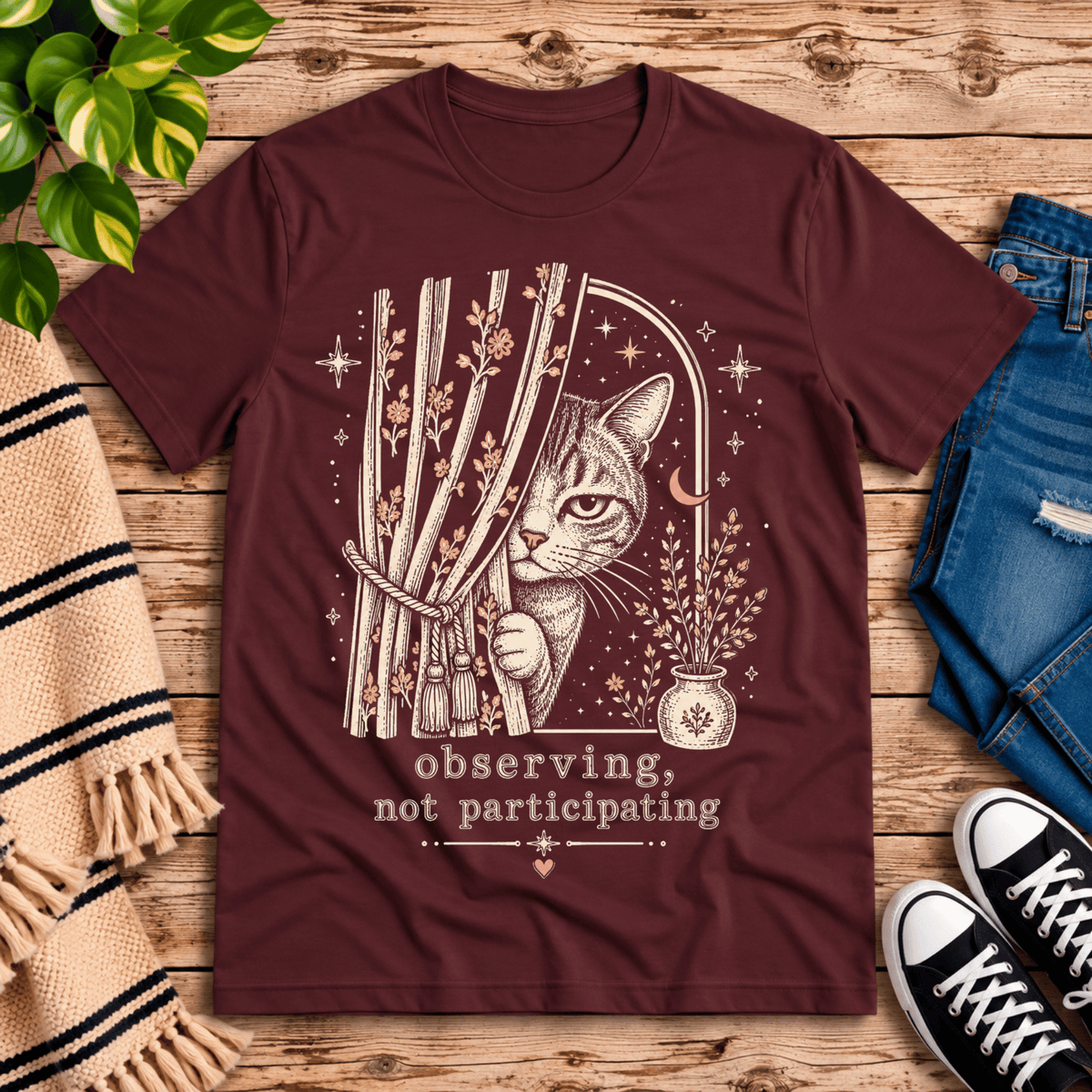 Cat Observing cute animal graphic t-shirt cozy flat lay in maroon.