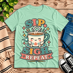 Sip. Sigh. Repeat. coffee graphic t-shirt cozy flat lay in mint.