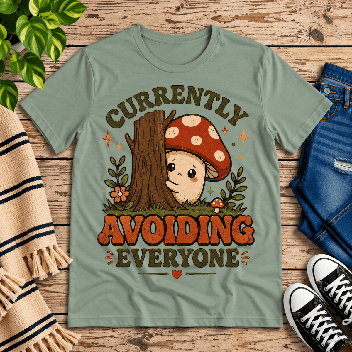 Currently Avoiding funny cottagecore graphic t-shirt cozy flat lay in sage.