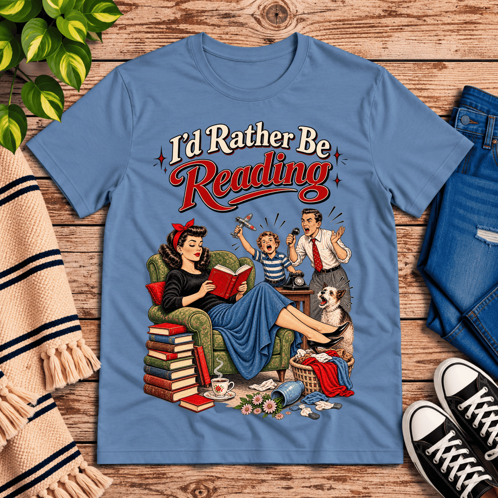 A cozy flat lay mockup of I'd Rather Be retro book graphic t-shirt in steel blue.