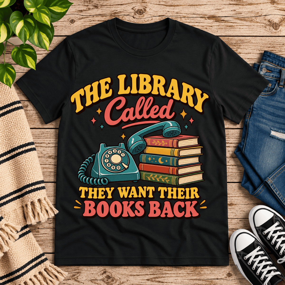 The Library Called book lovers graphic t-shirt cozy flat lay in vintage black.