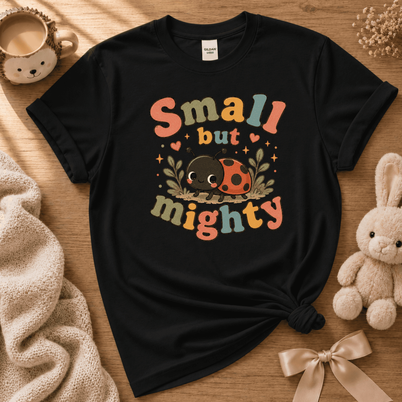 Small But Mighty cute animal graphic t-shirt cozy flat lay in black.