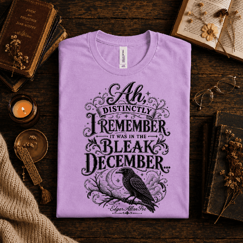 Bleak December Premium T-Shirt in lilac, folded close-up styled with books, dried flowers, and a candle