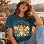 Woman wearing the Brighter Days Ahead Premium T-Shirt and matching cap outdoors by a mountain lake