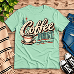 Coffee First Premium T-Shirt in mint, flat lay with vintage "Coffee First, everything else can wait" script and coffee cup graphic