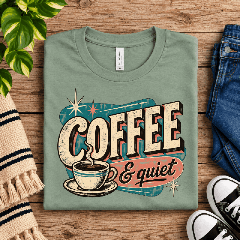 Coffee & Quiet Premium T-Shirt in sage green, folded close-up with neck tag showing