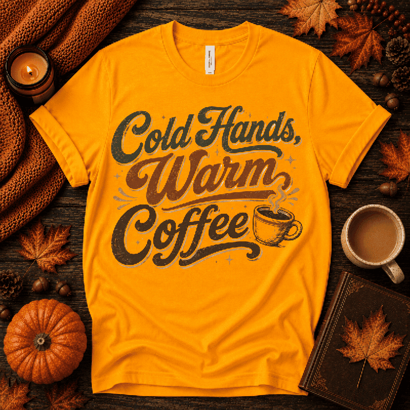 Cold Hands, Warm Coffee Premium T-Shirt in gold, flat lay with autumn props and steaming coffee cup script graphic