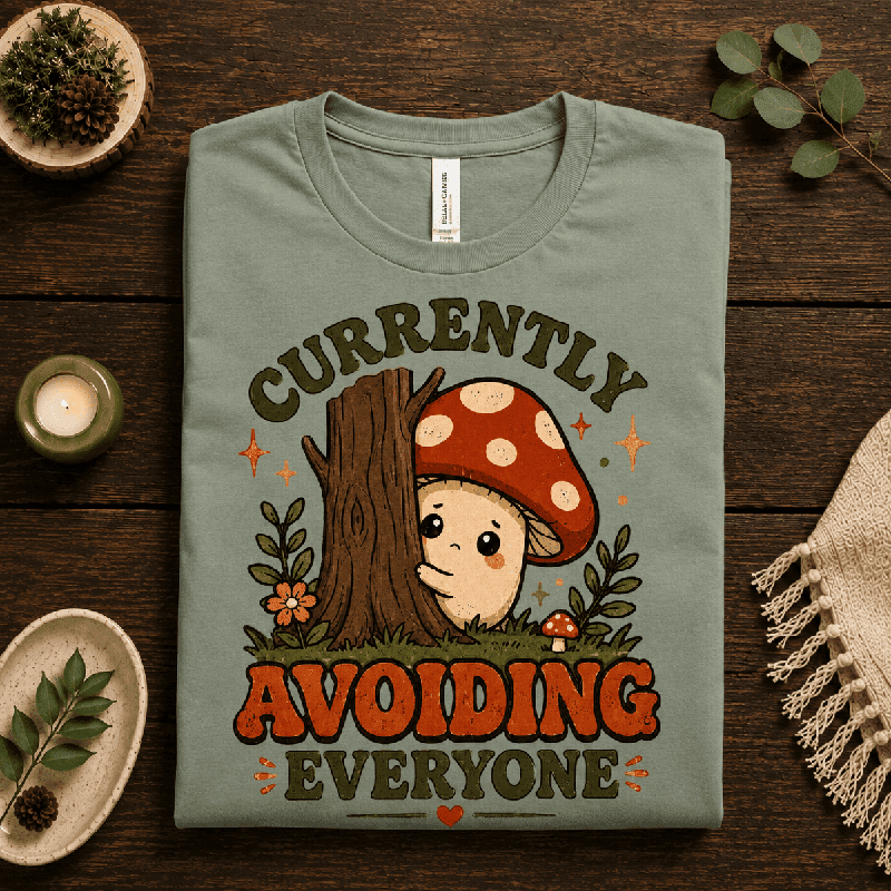 Currently Avoiding Premium T-Shirt in sage, folded close-up with neck tag showing