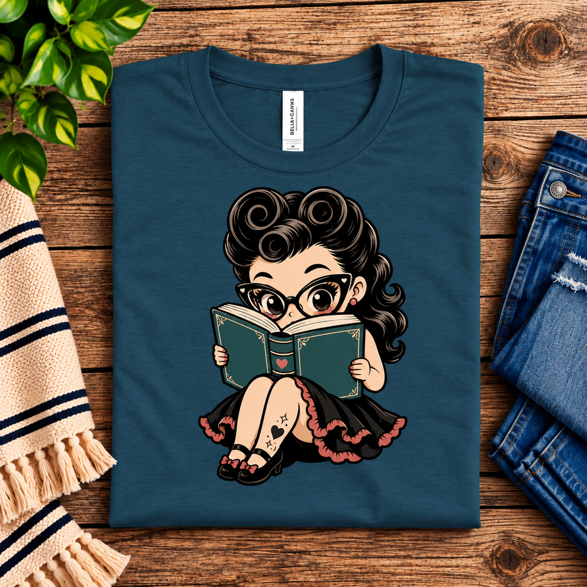 A folded mockup of Bookworm Betty vintage pinup graphic t-shirt in deep teal.