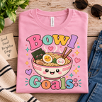 A folded mockup of Bowl Goals cute food graphic t-shirt in pink.