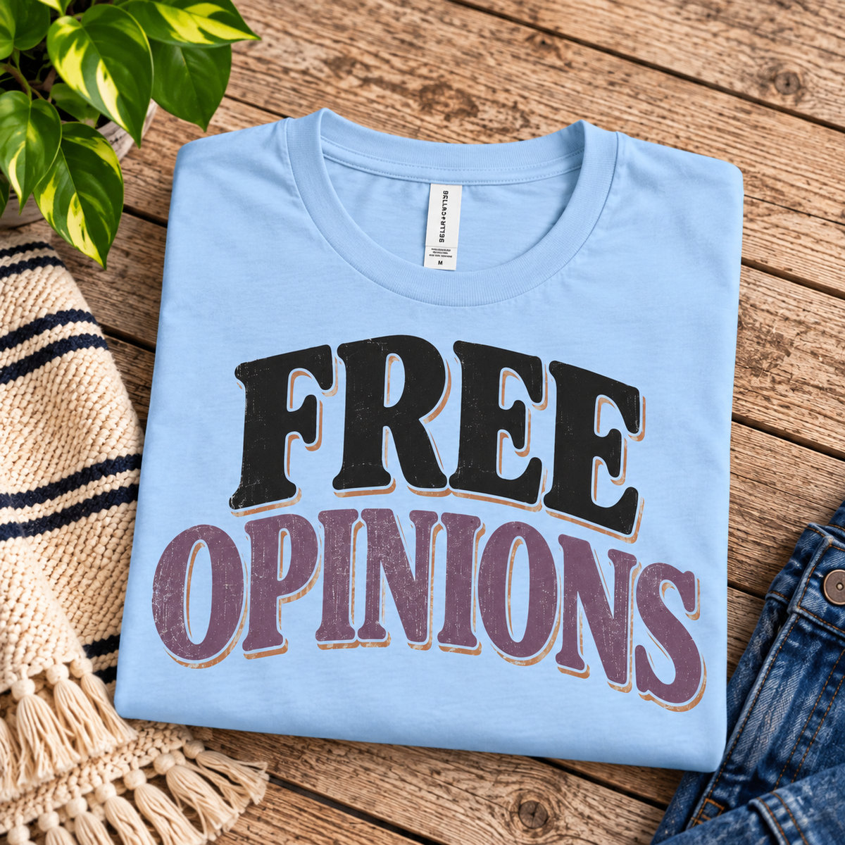 A folded mockup of Free Opinions funny introvert graphic t-shirt in baby blue.