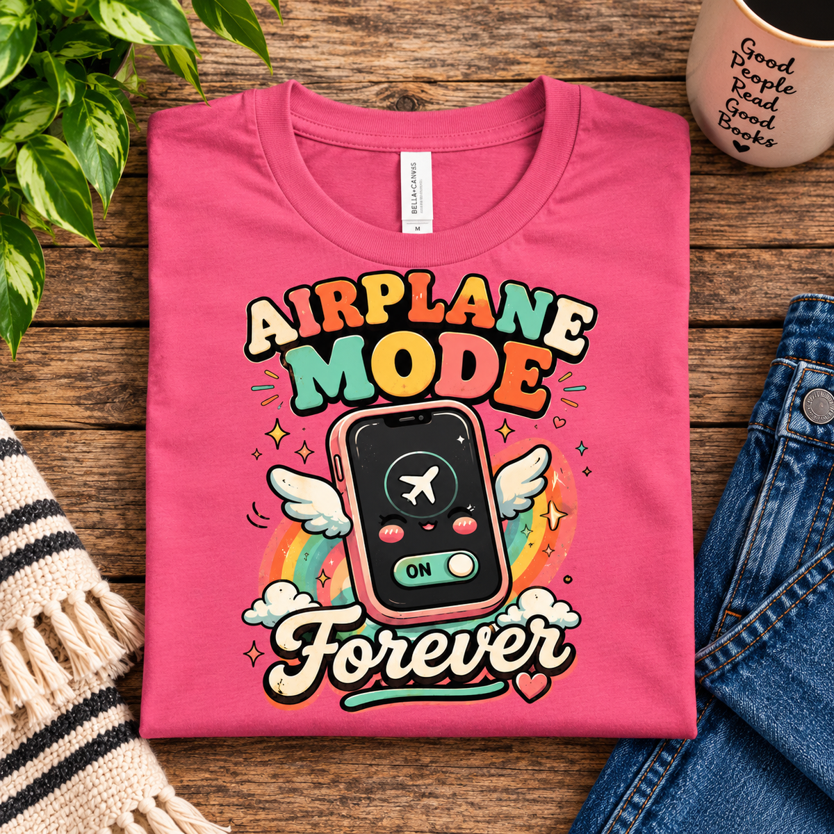 A folded mockup of Airplane Mode funny introvert graphic t-shirt in charity pink.