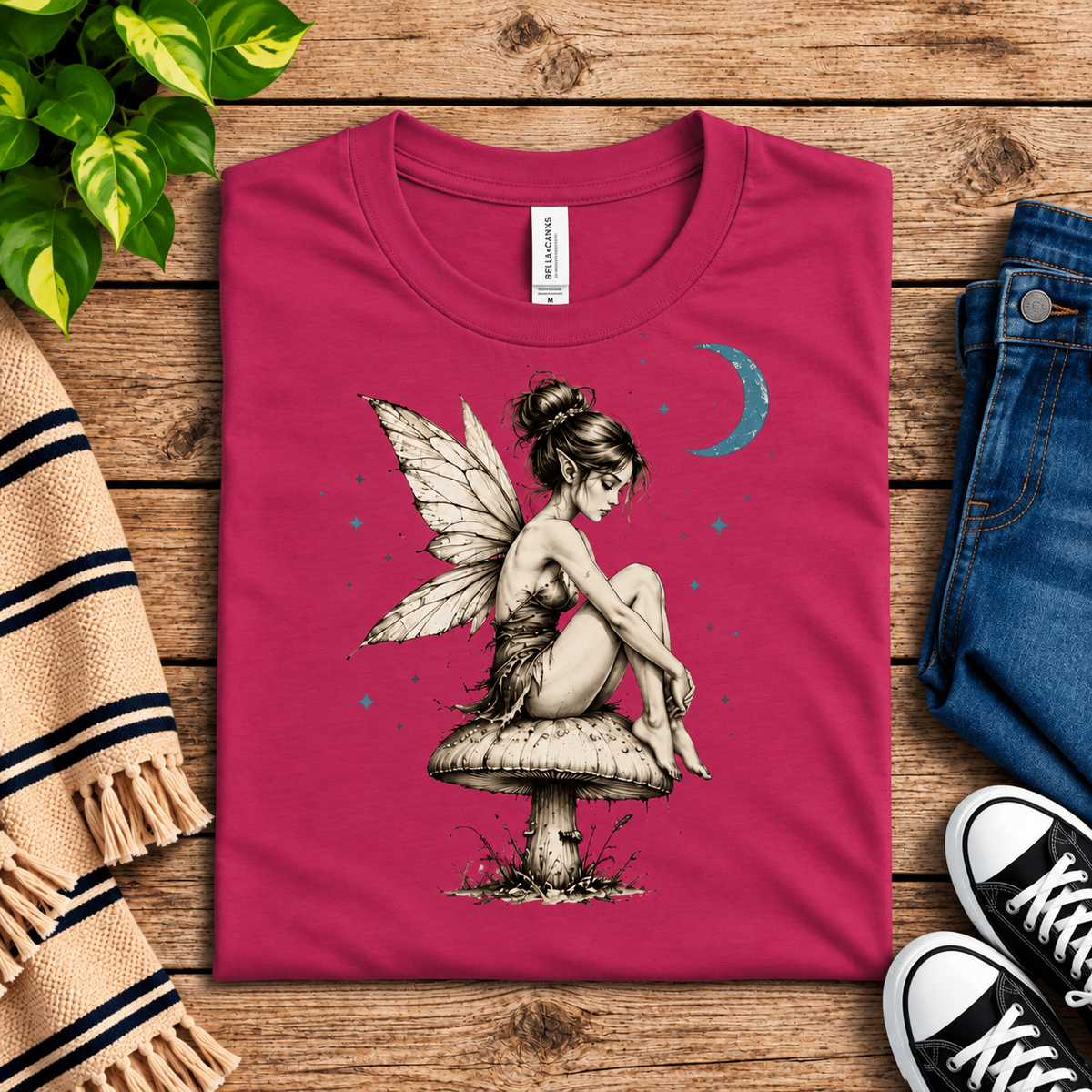 A folded mockup of Moonlit Fairy vintage fairy graphic t-shirt in berry.
